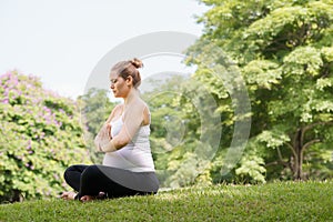 Pregnant woman mother belly relaxing park yoga prayer