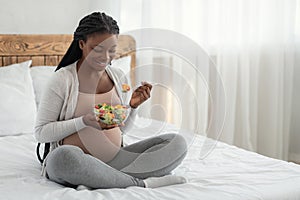 Pregnant Woman Nutrition. Happy Black Expecting Lady Eacting Vegetable Salad In Bed