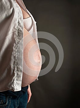 Pregnant woman with open shirt and bra