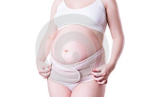 Pregnant woman with orthopedic support belt,  on white background