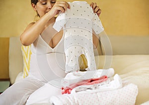 Pregnant woman is packing baby clothes