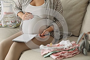 Pregnant woman packing bag for maternity hospital at home