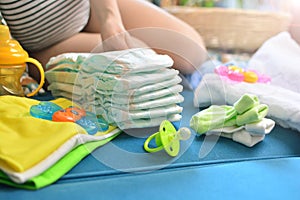 Pregnant woman packing bag for maternity hospital at home. Expectant mother folds clothes for a newborn