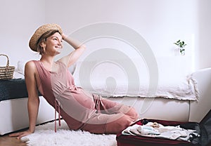 Pregnant woman packing suitcase for maternity hospital getting ready for newborn. Mother waiting for baby birth with travel