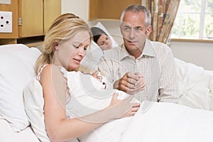 Pregnant woman in pain with husband in hospital