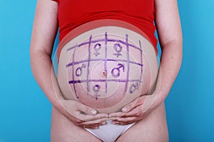 Pregnant woman with painted naught and crosses on belly photo