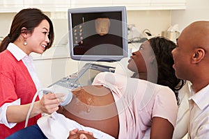 Pregnant Woman And Partner Having 4D Ultrasound Scan