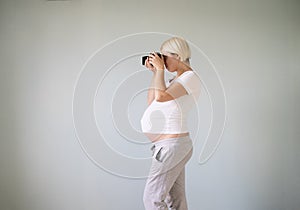 Pregnant woman photographer with a film camera