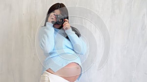 Pregnant woman photographer takes pictures on camera