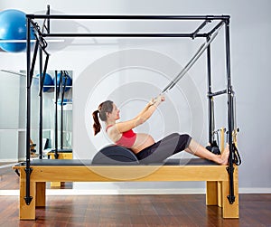 Pregnant woman pilates reformer roll up exercise photo