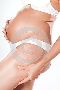 Pregnant woman pinching cellulite