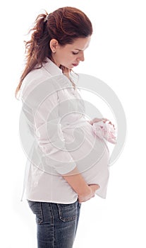 Pregnant woman with pink baby-shoes.