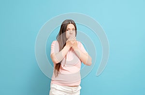 pregnant woman in pink t-shirt on blue background, toxicosis during pregnancy photo