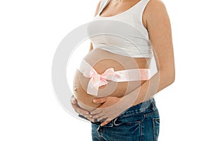 Pregnant woman with pink tape on her big belly posing isolated on white background