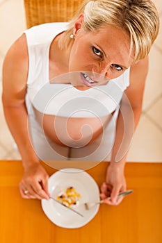 Pregnant woman with plate full of pills