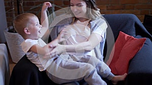 Pregnant woman playing with her son at home