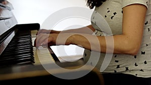 Pregnant woman playing the piano at home