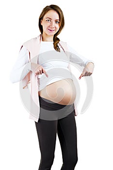 Pregnant woman pointing fingers on belly over white background