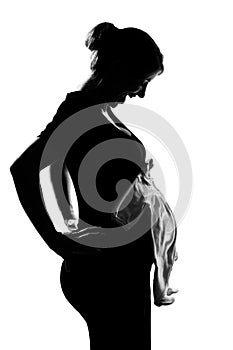 Pregnant woman portrait holding baby clothes