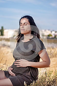 Pregnant woman poses on the dunes