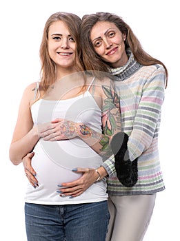 Pregnant woman posing with her mother in studio
