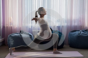 Pregnant woman practice yoga. A girl in the third trimester leads Pilates. Classes to prepare for childbirth. Waiting