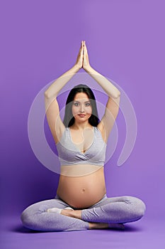 Pregnant woman practicing prenatal yoga, preparing body to natural childbirth