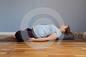 Pregnant woman practicing yoga in Reclined Butterfly exercise