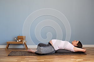 Pregnant woman practicing yoga in Reclined Butterfly exercise