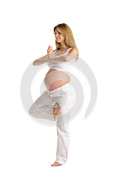 Pregnant woman practicing yoga, standing