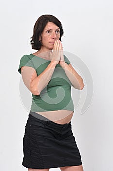 Pregnant woman praying on white background