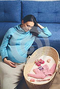 Pregnant woman preparing for baby birth her daughter. Last months of pregnancy. Beautiful pregnant woman at home