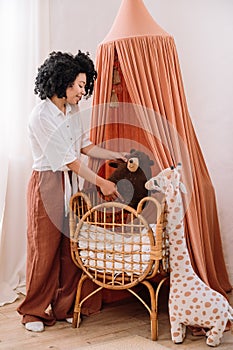 pregnant woman preparing cozy nursery room for her baby