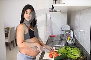 Pregnant woman preparing a green salad