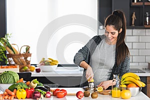 Pregnant woman preparing healthy food with lots of fruit and vegetables at home