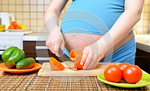 Pregnant woman preparing a healthy meal in the kitchen