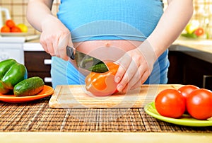 Pregnant woman preparing a healthy meal in the kitchen