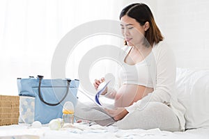 Pregnant woman preparing hospital bag checklist