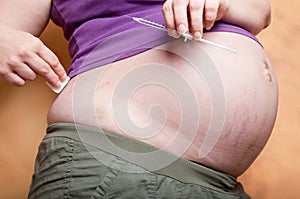 Pregnant woman preparing an injection