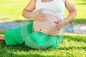 Pregnant woman protecting her belly with sunscreen cream