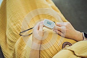 Pregnant woman with pulse oximeter on finger. Doctor measuring oxygen saturation level while visiting expectant mother