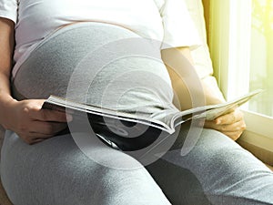 Pregnant woman reading book.