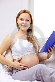 Pregnant woman reading book at home