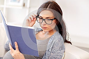 Pregnant woman reading book at home