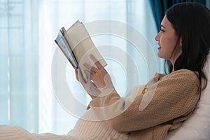 Pregnant woman reading a stories to her unborn child in the living room