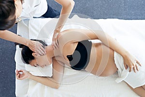 Pregnant woman receiving osteopathic or chiropractic treatment in neck in a clinic