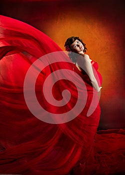 Pregnant woman in red flying waving dress.