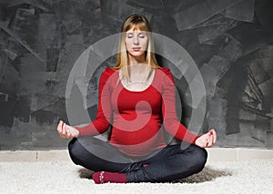 Pregnant woman in red jacket doing yoga