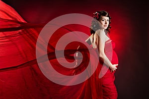 Pregnant woman in red waving dress