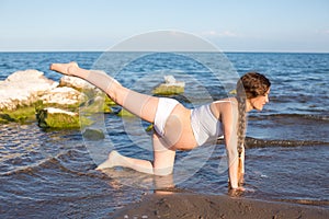 Pregnant woman in relaxation on yoga pose on sea